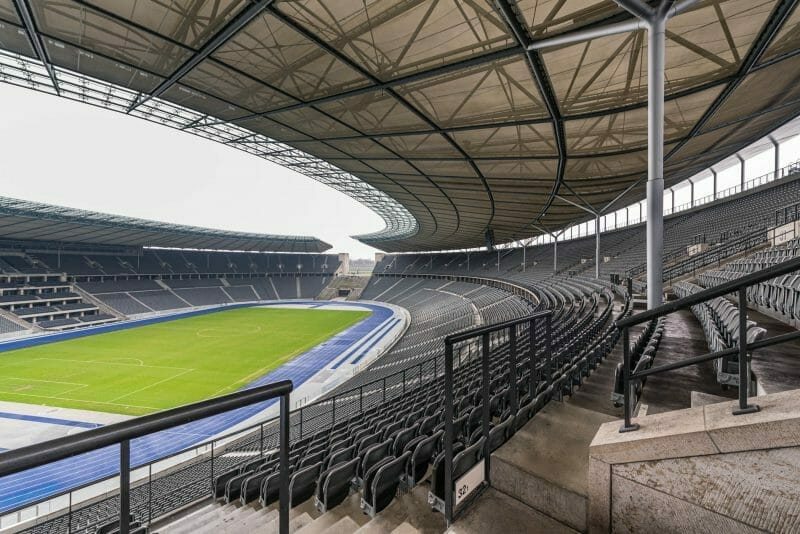 Architekturfoto vom Berliner Olympiastadion. Man sieht von den Rängen aus in das große Rund des Stadions.