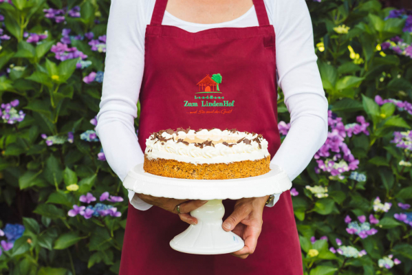 Aussagekräftige Fotos für Ihr Hotel-Unternehmen. Hotelmitarbeiter präsentiert eine Torte.