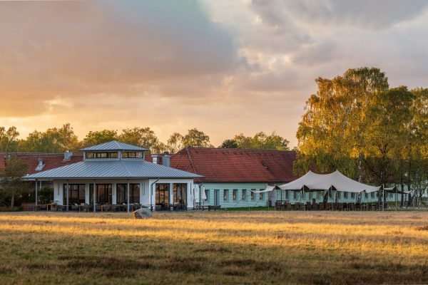Hotelcamp Reinsehlen - Hotelgelände im Abendlicht Außengelände mit Blick auf den Restaurantbereich vom Hotelcamp Reinsehlen in der Lüneburger Heide im Abendlicht