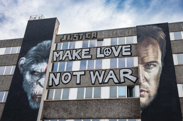Kunst an einer Berliner Fassade, die mit dem Spruch "Make love not war" beschrieben ist