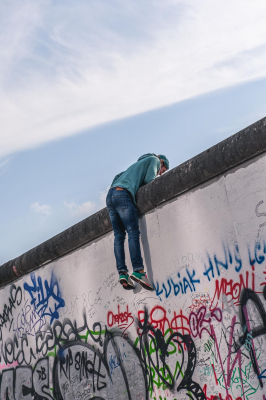 Junger Mann hat die Berliner Mauer erklommen