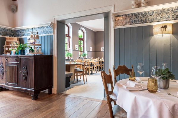 LandHaus "Zum Lindenhof" Marxen in der Nordheide stimmungsvolle Restauranträume mit gedecktem Tisch im Anschnitt und Durchblick in den Gastraum