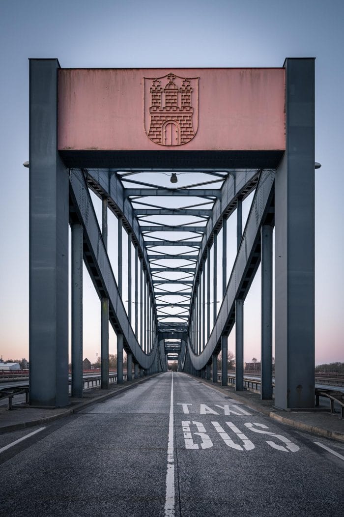 alte Stahl-Elbbrücke mit Hamburger Wappen und zwei großen Schriftzügen auf der Straße für die Taxi- und Busspur