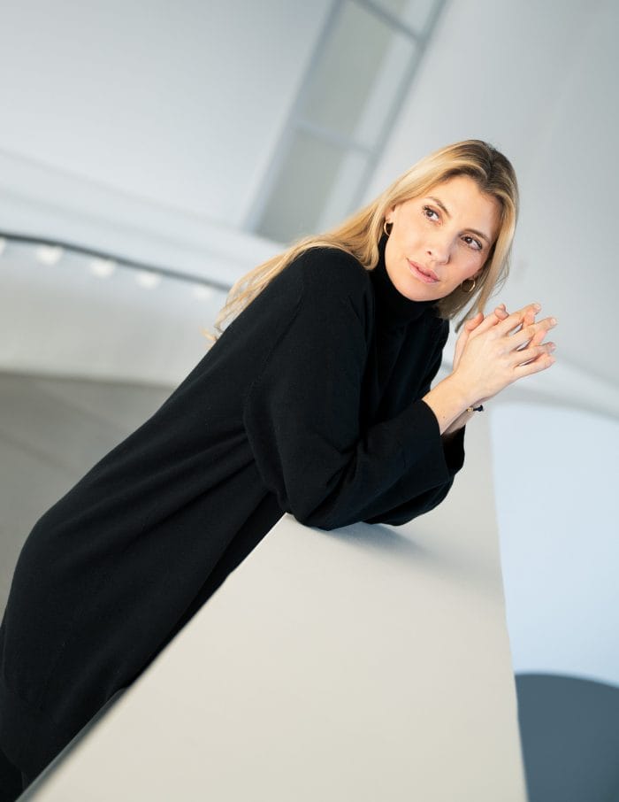 Frauenporträt im langen schwarzen Pullover im hellen Raum des Sprengel Museums